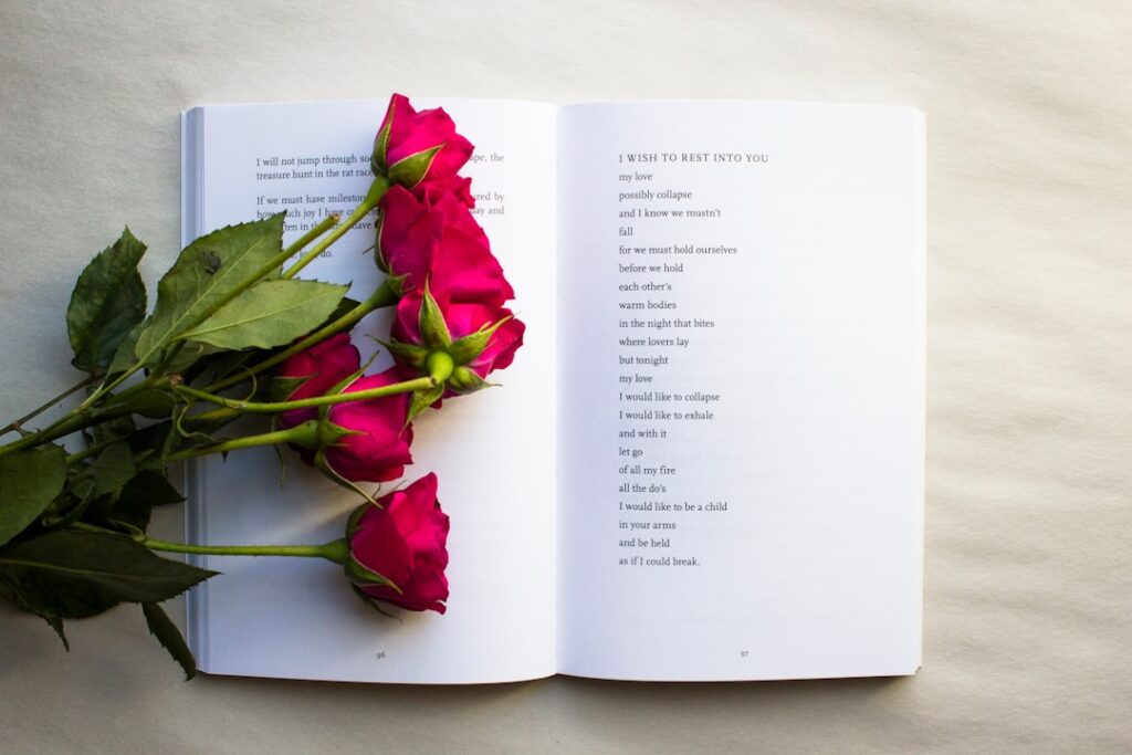 A group of people gathered around a table reading poetry aloud from books.
