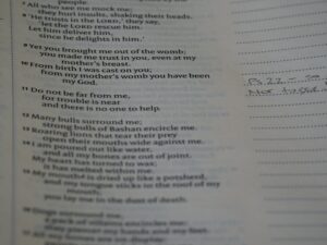 A teacher and students discussing poetry with open notebooks on a classroom table.