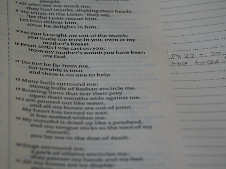 A teacher and students discussing poetry with open notebooks on a classroom table.